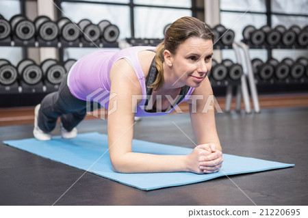 Determined woman planking on the mat 21220695