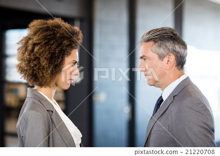 Businessman and businesswoman standing face to face Businessman and businesswoman standing face to face 21220708