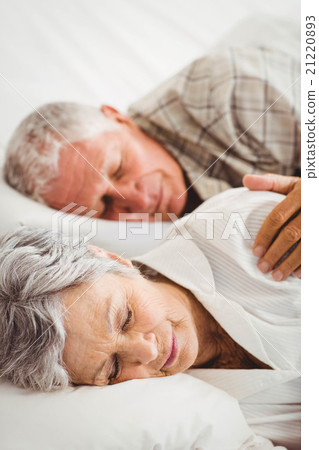 Senior couple sleeping on bed 21220893