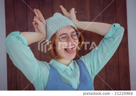 Cute red haired hipster making bunny ears Cute red haired hipster making bunny ears 21220968
