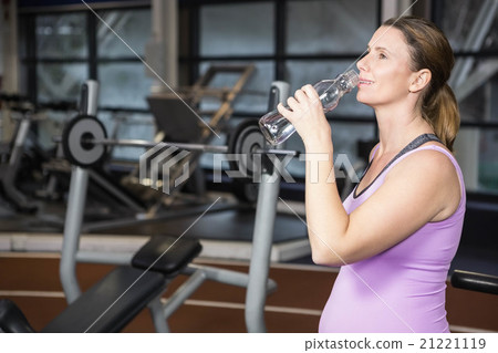 Smiling pregnant woman drinking water 21221119
