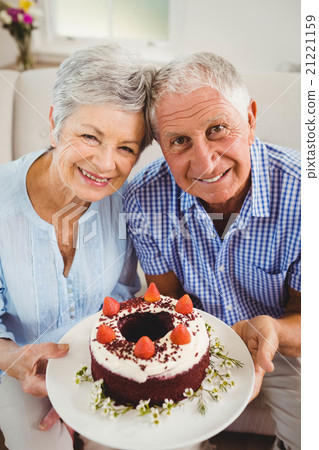 Senior couple holding a cake Senior couple holding a cake 21221159