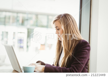 Cute blonde girl using her laptop 21221449