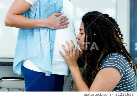 Woman kissing on pregnant partners stomach Woman kissing on pregnant partners stomach 21221688