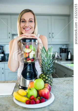 Pretty blonde woman preparing a smoothie Pretty blonde woman preparing a smoothie 21222255