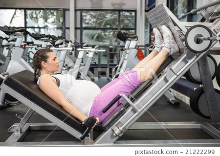 Pregnant woman using weight machine Pregnant woman using weight machine 21222299