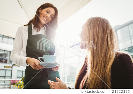 Smiling waitress serving a coffee Smiling waitress serving a coffee 21222355