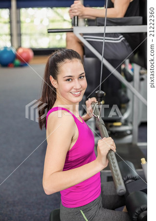 Fit woman using weight machine Fit woman using weight machine 21222360