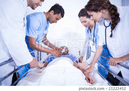 Doctors examining a patient on bed Doctors examining a patient on bed 21222452