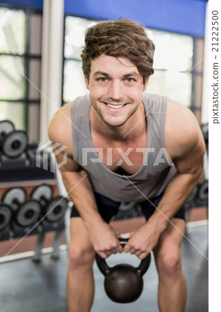 Handsome man lifting dumbbells 21222500