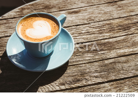 Cup of cappuccino with coffee art on wooden table Cup of cappuccino with coffee art on wooden table 21222509