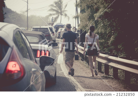 A couple walking on a sidewalk A couple walking on a sidewalk 21232850