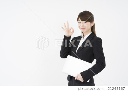 一個女人在她年輕,美麗,美麗和可愛的西裝,輕輕地微笑著與便攜式計算機的確定標誌 一個女人在她年輕,美麗,美麗和可愛的西裝,輕輕地微笑著與便攜式計算機的確定標誌 21245167