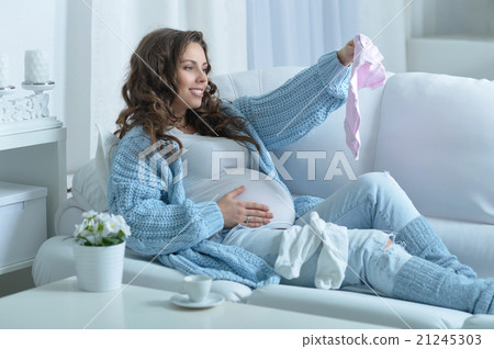 pregnant woman with baby clothes 21245303