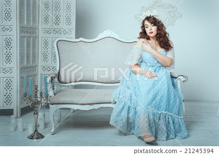 Woman sitting on sofa in the room. 21245394