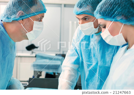 Stock Photo: Skillful doctors are operating in surgery