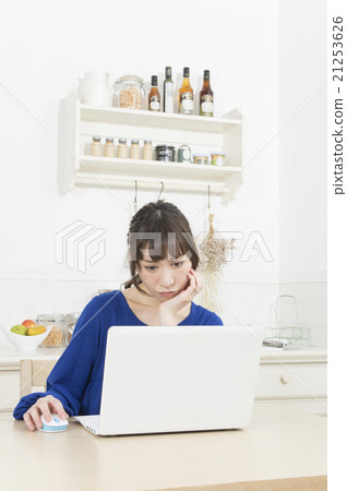 A woman thinking while watching a computer 21253626
