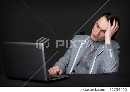 tired caucasian guy sitting in front of computer tired caucasian guy sitting in front of computer 21254430
