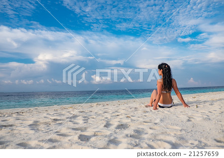Girl walking along a tropical beach in the Maldives. Girl walking along a tropical beach in the Maldives. 21257659