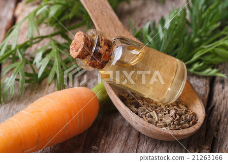 Useful carrot seed oil in glass bottle closeup Useful carrot seed oil in glass bottle closeup 21263166