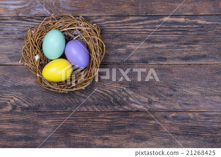 Easter colorful eggs in bird nest on wood 21268425