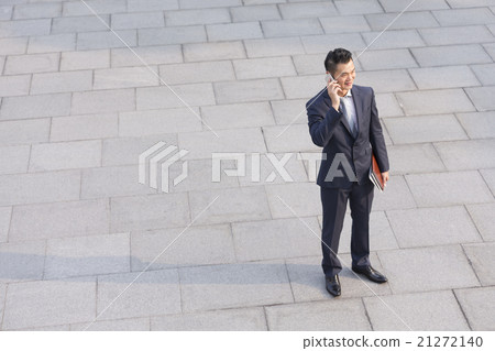 Asian business man talking on his smart phone. Asian business man talking on his smart phone. 21272140