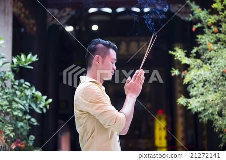 Asian man praying in a temple. Asian man praying in a temple. 21272141
