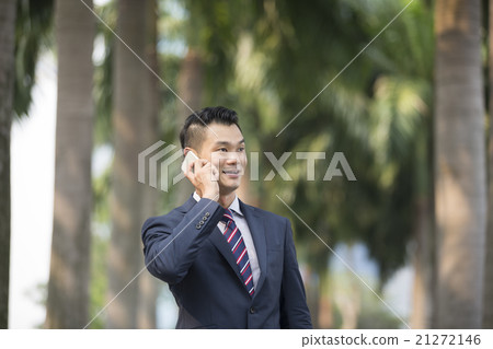 Asian business man talking on his smart phone. Asian business man talking on his smart phone. 21272146