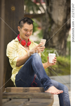 happy Asian man relaxing outdoors. happy Asian man relaxing outdoors. 21272147