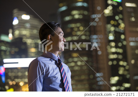 Chinese businessman standing outdoors at night. 21272171