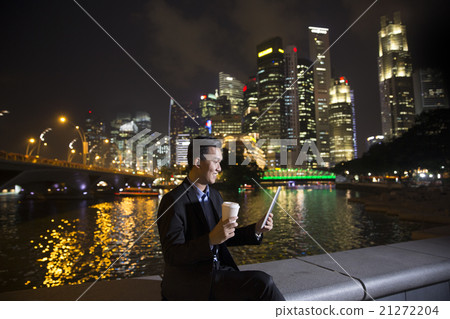 Chinese businessman outdoors at night using his digital tablet d 21272204