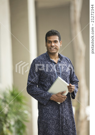 Indian man wearing a kurta and using tablet computer. 21272344