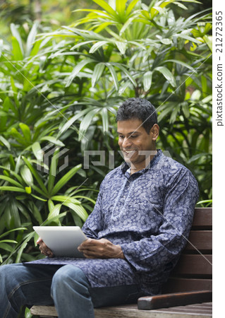 Indian man wearing a kurta and using tablet computer. Indian man wearing a kurta and using tablet computer. 21272365