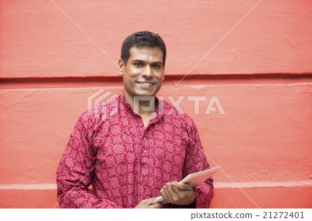 Indian man wearing a kurta and using tablet computer. 21272401