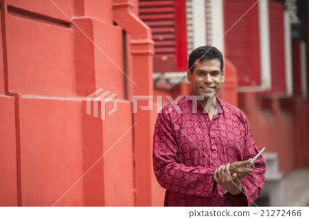 Indian Man standing using his Smart Phone. Indian Man standing using his Smart Phone. 21272466