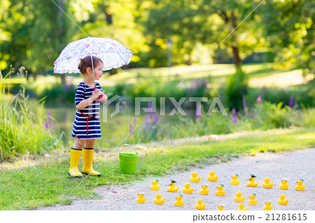 Little girl playing in forest and wearing boots Little girl playing in forest and wearing boots 21281615