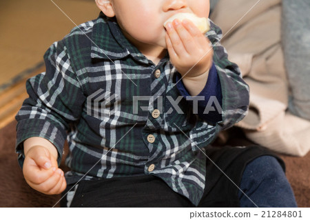 An infant eating an apple 21284801