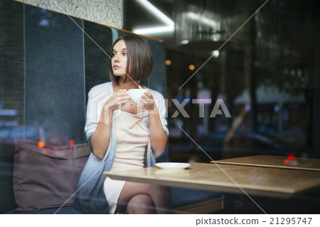 Beautiful woman drinking coffee in city cafe Beautiful woman drinking coffee in city cafe 21295747