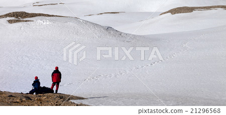 Two hikers on halt in snowy mountain Two hikers on halt in snowy mountain 21296568
