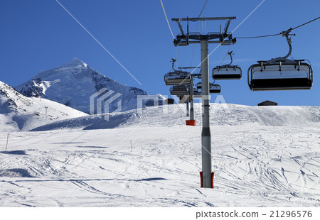 Chair lift in snowy mountains at nice sunny day 21296576
