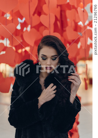 Beautiful girl on a background of red hearts Beautiful girl on a background of red hearts 21296766