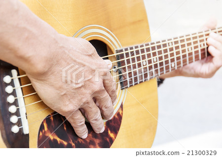 Hand of old man on playing guitar 21300329