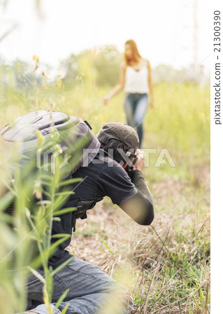 Man photographing young beautiful woman against  21300390