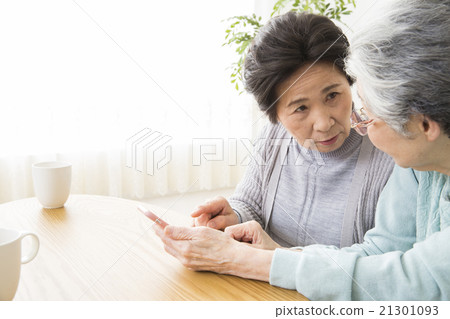 Two senior women who operate smartphones 21301093