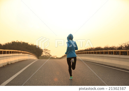 young fitness woman runner running on sunrise road young fitness woman runner running on sunrise road 21302387