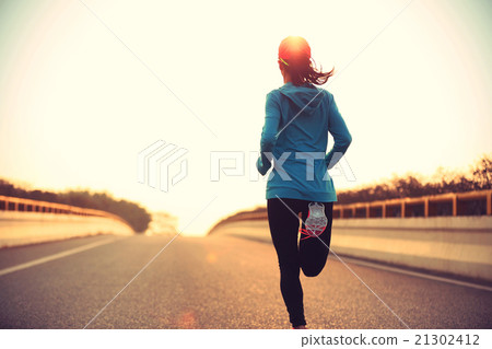 young woman runner running at sunrise city road young woman runner running at sunrise city road 21302412