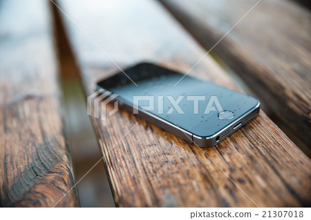 phone in the rain on a wooden bench phone in the rain on a wooden bench 21307018