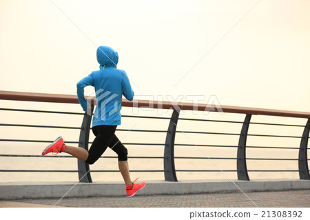 young fitness woman runne running at seaside road 21308392