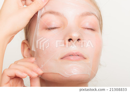 girl removing facial peel off mask 21308833