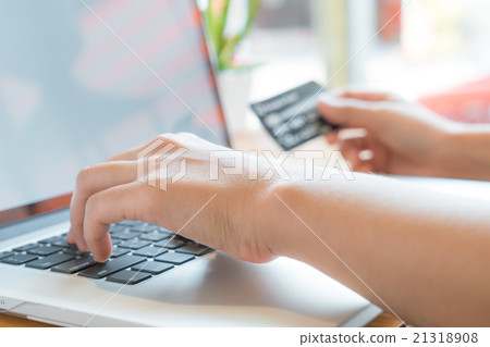 Hands holding a credit card and using laptop computer for online 21318908